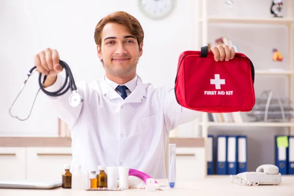 Jovem médico com kit de primeiros socorros no hospital — Fotografia de Stock