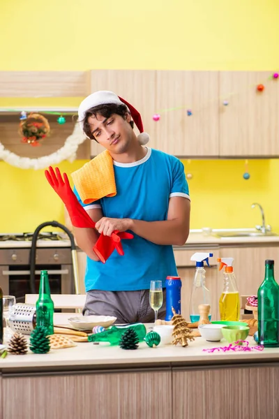 Mladý muž čištění kuchyně po vánoční večírek — Stock fotografie