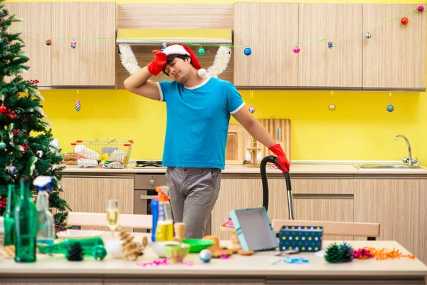 Giovane uomo pulizia cucina dopo la festa di Natale — Foto Stock