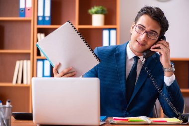 Genç yakışıklı işadamı ofiste çalışıyor.