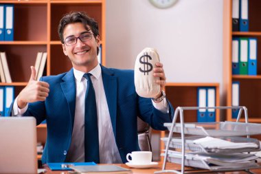 Genç yakışıklı işadamı ofiste çalışıyor.