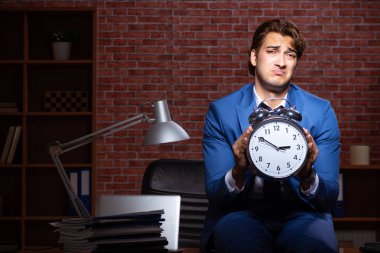 Genç işadamı geceleri ofiste çalışıyor. 