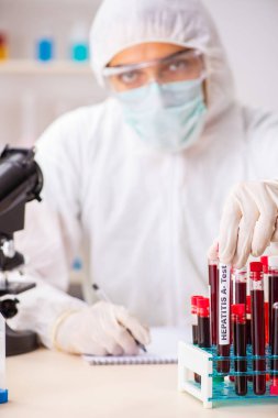 Genç yakışıklı laboratuvar asistanı hastanede kan örnekleri test ediyor. 