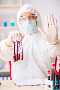 Genç yakışıklı laboratuvar asistanı hastanede kan örnekleri test ediyor. 