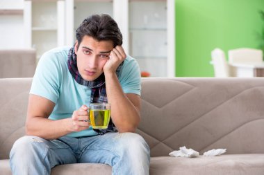 Evde hastalıktan muzdarip genç yakışıklı bir adam. 