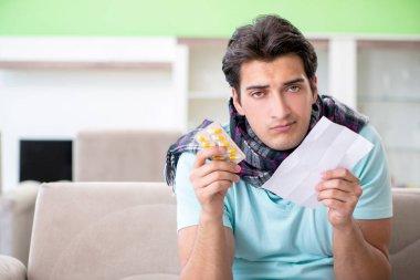 Evde hastalıktan muzdarip genç yakışıklı bir adam. 