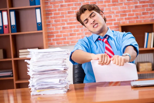 Junge Angestellte mit exzessiver Arbeit im Büro — Stockfoto