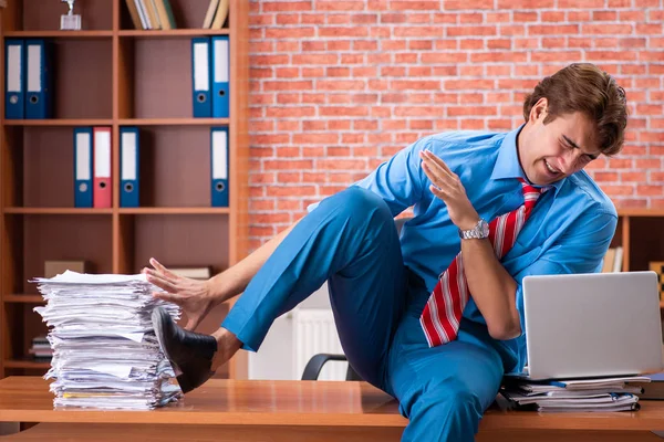 Молодий працівник з надмірною роботою сидить в офісі — стокове фото