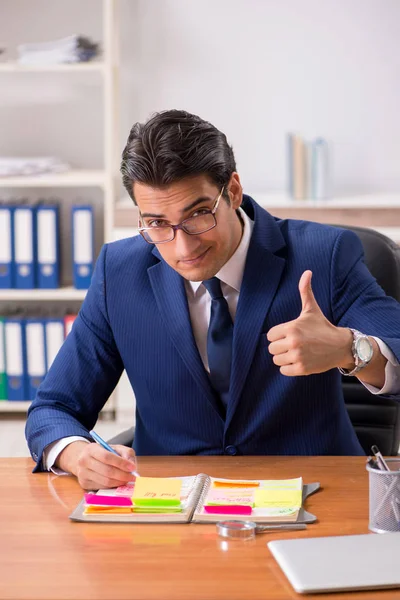 Joven empleado guapo planeando su actividad laboral —  Fotos de Stock