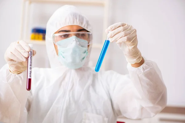 Asistente de laboratorio joven guapo analizando muestras de sangre en el hospital — Foto de Stock