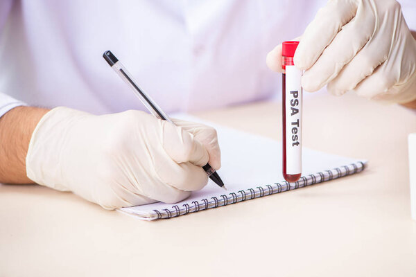 Young handsome lab assistant testing blood samples in hospital 
