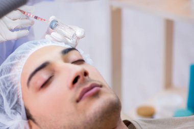 Adam estetik ameliyat için doktoru ziyaret ediyor. 