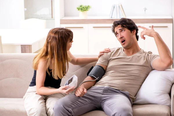 Wife checking husbands blood pressure