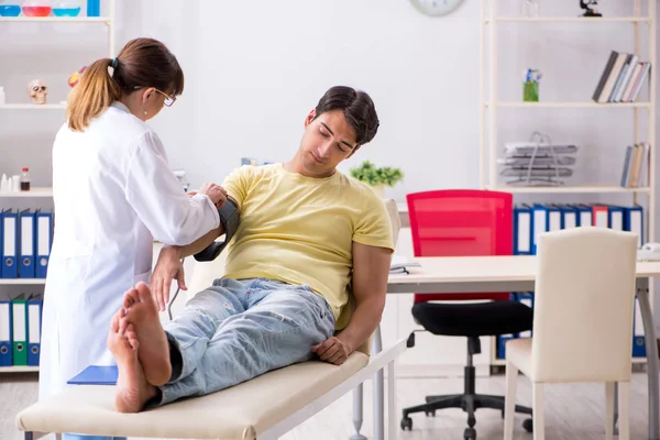 Médico joven revisando pacientes presión arterial — Foto de Stock