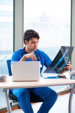 Hastanede çalışan yakışıklı genç bir doktor. 