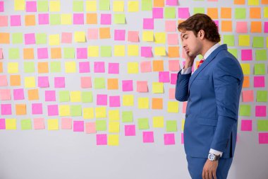 Çelişkili öncelikler konseptinde genç yakışıklı bir adam 