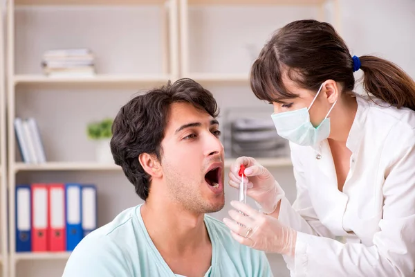 Jeune homme beau visitant le médecin dentiste féminin pour le retrait de — Photo