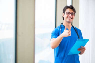 Hastanede çalışan yakışıklı genç bir doktor. 