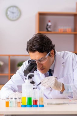 Genç yakışıklı biyokimyacı laboratuvarda çalışıyor.  