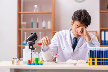 Genç yakışıklı biyokimyacı laboratuvarda çalışıyor. 