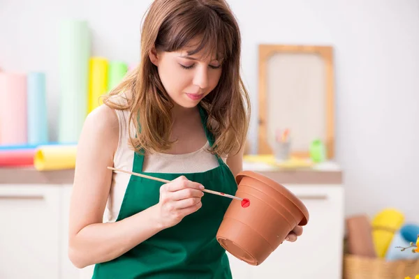 Молодая женщина украшает керамику в мастерской — стоковое фото