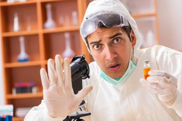 Młody biochemik w kombinezonie ochronnym pracujący w laboratorium — Zdjęcie stockowe
