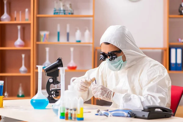 Jovem bioquímico vestindo roupa protetora trabalhando no laboratório — Fotografia de Stock
