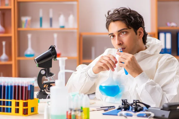 Joven bioquímico con traje protector trabajando en el laboratorio —  Fotos de Stock