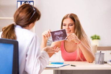 Güzel hamile kadın, kadın jinekoloğu ziyaret ediyor.  