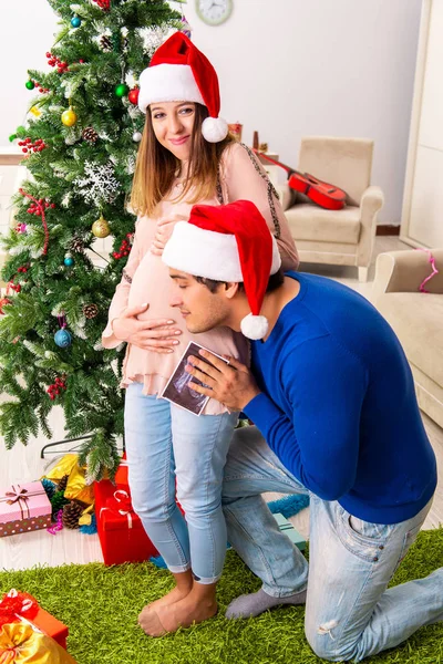 Zwangere vrouw celevrating kerst met man — Stockfoto