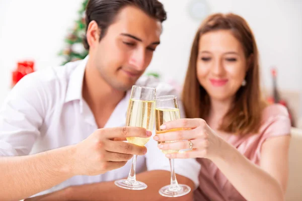Pareja joven celebrando la Navidad con champán — Foto de Stock