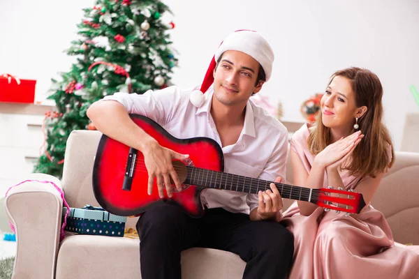 Jovem casal tocando guitarra no Natal — Fotografia de Stock