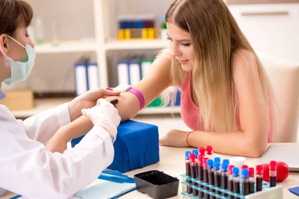 Mulher bonita jovem durante o procedimento de amostragem de teste de sangue — Fotografia de Stock