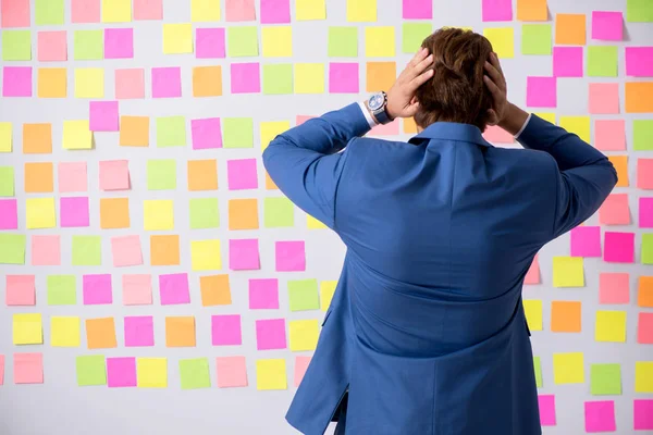 Joven hombre guapo en concepto de prioridades contradictorias — Foto de Stock