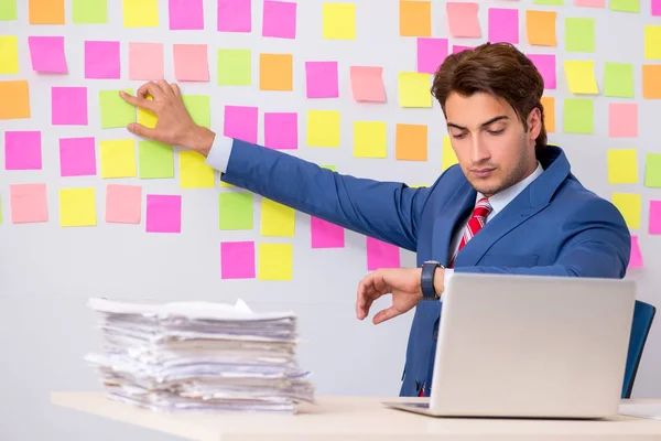 Young handsome man in conflicting priorities concept — Stock Photo, Image