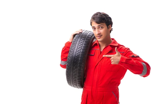 白色隔离轮胎的年轻修车工人 — 图库照片