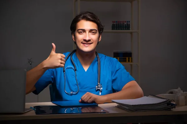 Joven médico guapo trabajando turno de noche en el hospital —  Fotos de Stock