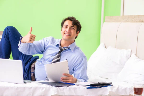 Empresário trabalhando horas extras no quarto de hotel — Fotografia de Stock