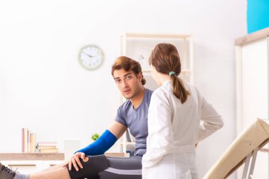 Genç erkek hasta, kadın doktor travmatoloğu ziyaret ediyor. 