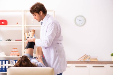 Genç bayan hasta erkek doktor travmatoloğu ziyaret ediyor. 