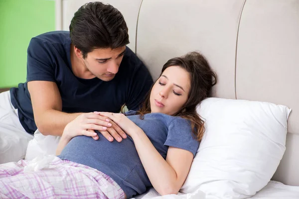 Mladý manžel dohlíží na jeho těhotnou ženu — Stock fotografie