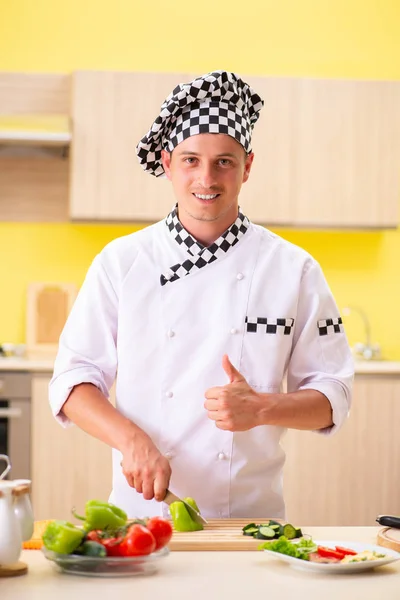 Jovem cozinheiro profissional preparando salada na cozinha — Fotografia de Stock