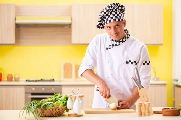 Jovem cozinheiro profissional preparando salada na cozinha — Fotografia de Stock