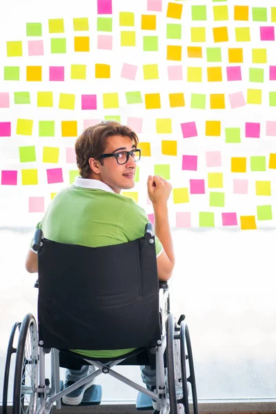 Молодой студент в инвалидной коляске со многими противоречивыми приоритетами — стоковое фото
