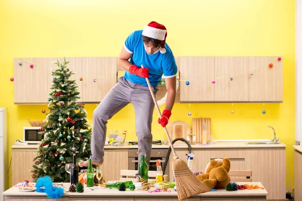 Young man cleaning kitchen after Christmas party — Stock Photo, Image