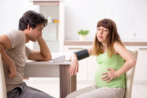 Manžel kontroluje těhotné ženy krevní tlak — Stock fotografie