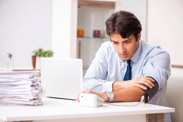 Hombre bajo estrés midiendo su presión arterial — Foto de Stock