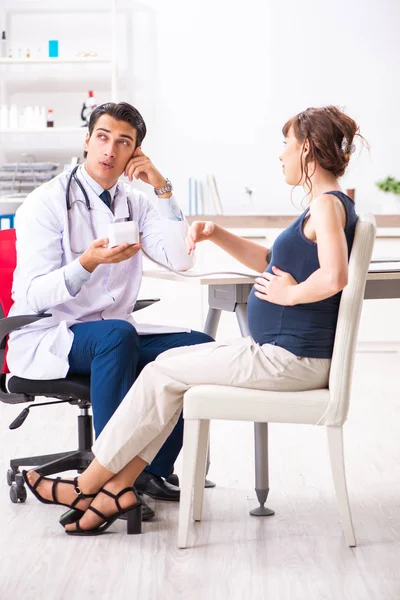 Jonge arts controleert zwangere vrouwen bloeddruk — Stockfoto