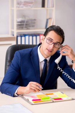 Çalışmalarını planlayan genç yakışıklı bir çalışan. 