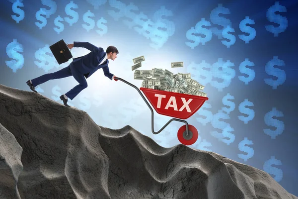 Biznesmen pchanie taczki z pieniędzy podatkowych — Zdjęcie stockowe
